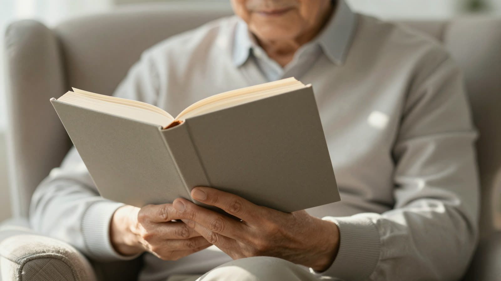 Older adult using a bookmark as a pacer for reading a printed book.